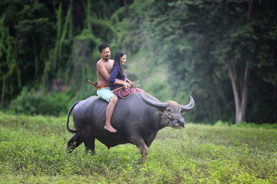 Full length of man riding horse on field