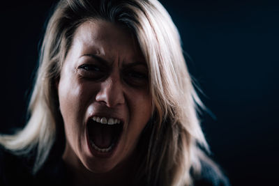 Portrait of mid adult woman against black background