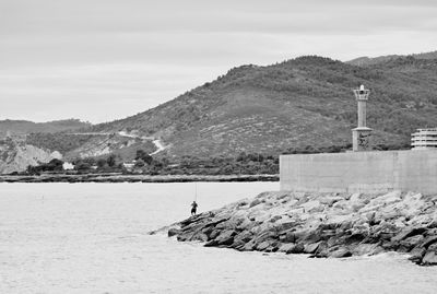 View of man fly fishing at seashore