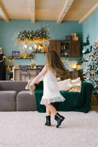 Cute little girl dancing near the christmas tree. children's joy in the new year holidays person