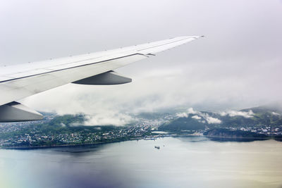 Airplane flying over sea against sky