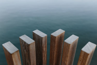 High angle of modern wooden beams placed near pond with calm water at daytime