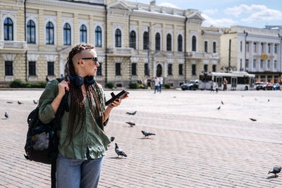 Portrait of woman standing on street in city