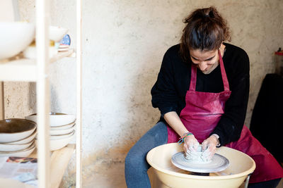 Ceramist artist female working in her atelier with the pottery wheel