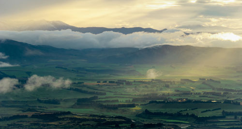 Sunrise rays hitting the green valley landscape, kepler track, fiordland national park, new zealand