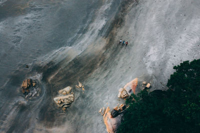 High angle view of people on rocks by sea