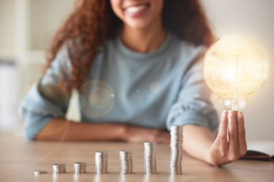 Portrait of woman holding light bulb