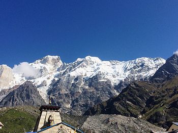 Scenic view of snowcapped mountains against clear blue sky