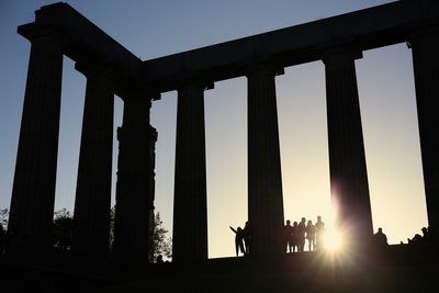 Low angle view of silhouette people against sky during sunset