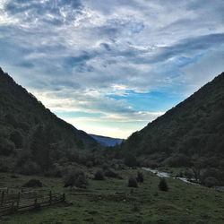 Scenic view of mountains against cloudy sky