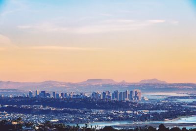 Aerial view of city at waterfront during sunset