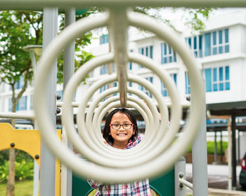 Portrait of a young girl wearing glasses playing at the playground in the garden.