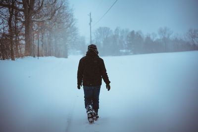 Rear view of man on snow covered landscape