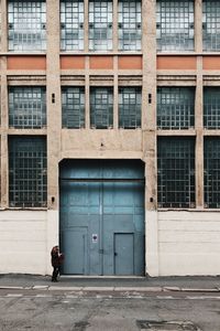 Man walking on footpath against building