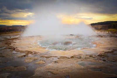 Scenic view of steam emitting from geyser