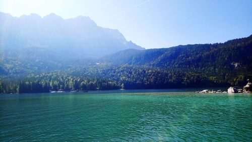 Scenic view of lake by mountains against clear sky