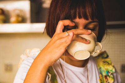 Close-up of woman drinking coffee in cup