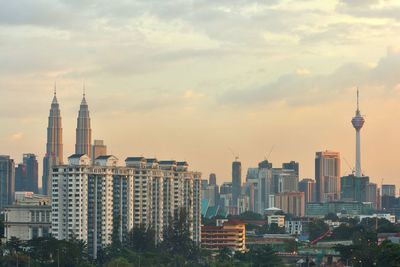 Menara kuala lumpur and petronas towers against sky in city