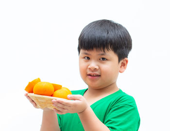 Cute boy holding apple against white background