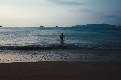 Silhouette man on beach against sky