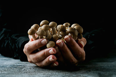 Close-up of hand holding food over black background