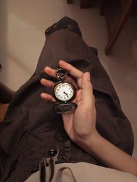 Cropped hand of person holding pocket watch