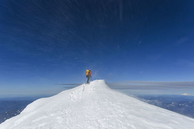 A man climbs to the summit of mt. hood in oregon.