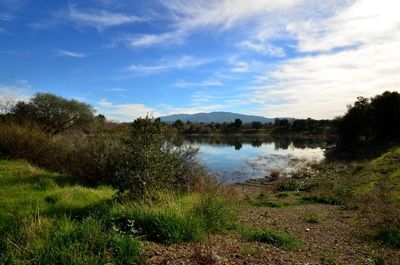 Scenic view of lake against cloudy sky