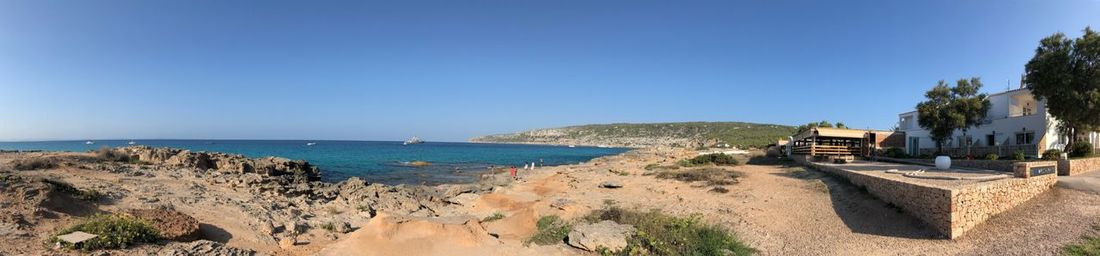 Panoramic view of beach against clear blue sky