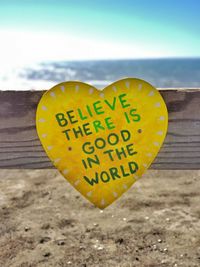 Close-up of text on heart shape against sky