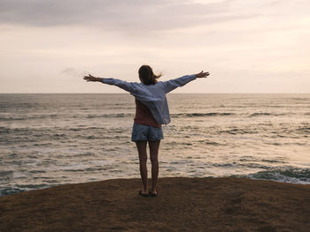 Full length rear view of man standing on beach