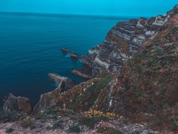 Rock formations by sea against sky