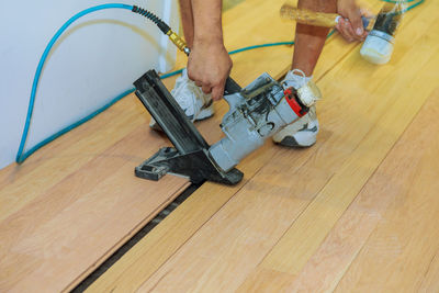 Low section of man on hardwood floor at home