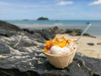 Close-up of chocolate on beach against sky