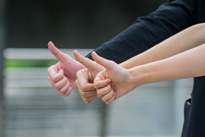 Cropped hands of people showing thumbs up