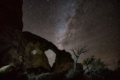 Man on rock against sky at night