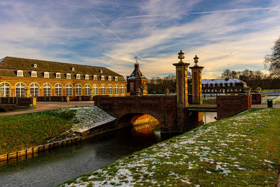 Bridge over river against cloudy sky