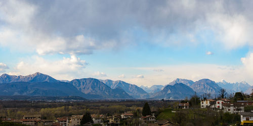 Panoramic view of townscape by mountains against sky