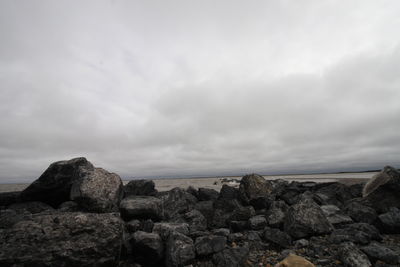 Rocks by sea against sky