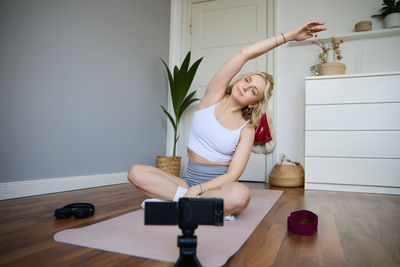 Portrait of young woman exercising at home