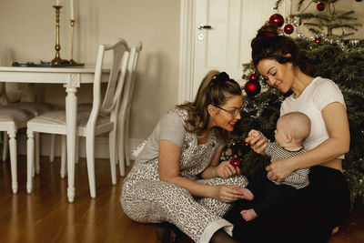 Mothers with baby near christmas tree