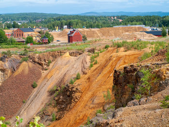 Falun copper mine the world heritage with orange mountain visible and tourist spot in background.