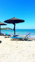 Scenic view of beach against clear blue sky