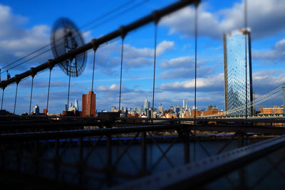 Bridge over river against cloudy sky