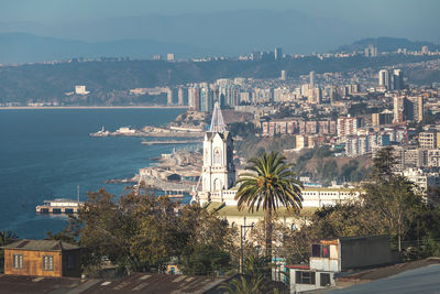 High angle view of city by sea against sky