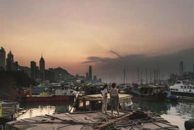 Sailboats in city at sunset