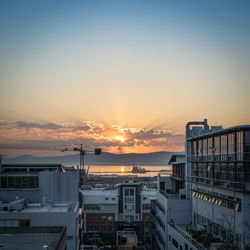 High angle view of city buildings against sky during sunset