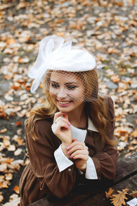 Young woman holding umbrella while sitting outdoors