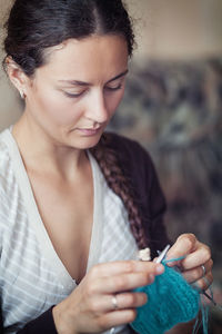 A young woman with dark hair braided in a pigtail and a striped dress 