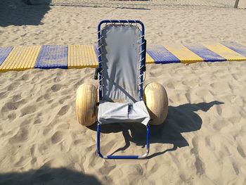 High angle view of chair on sand at beach